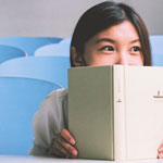 girl grinning looking over book